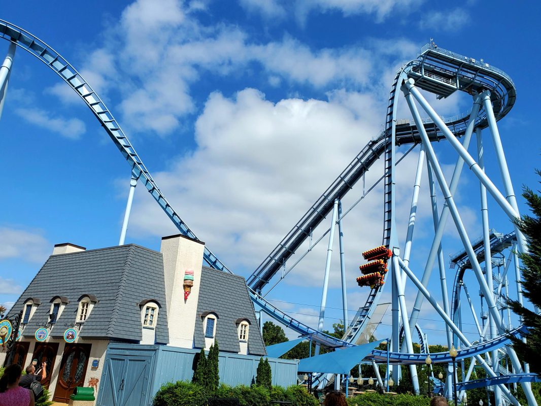 A French-style ice cream shop with a roller coaster in the background