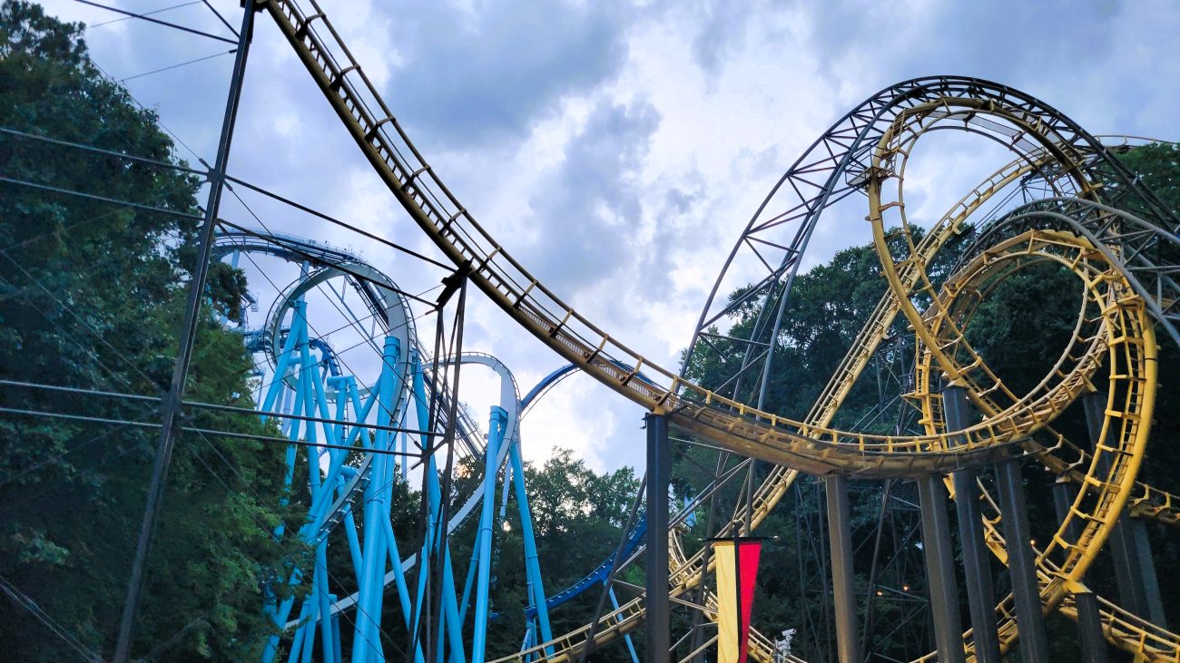 Bright yellow roller coaster with a blue coaster in the background