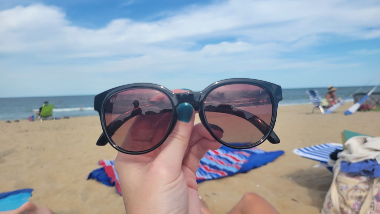 Floating sunglasses at the beach with the ocean in the background