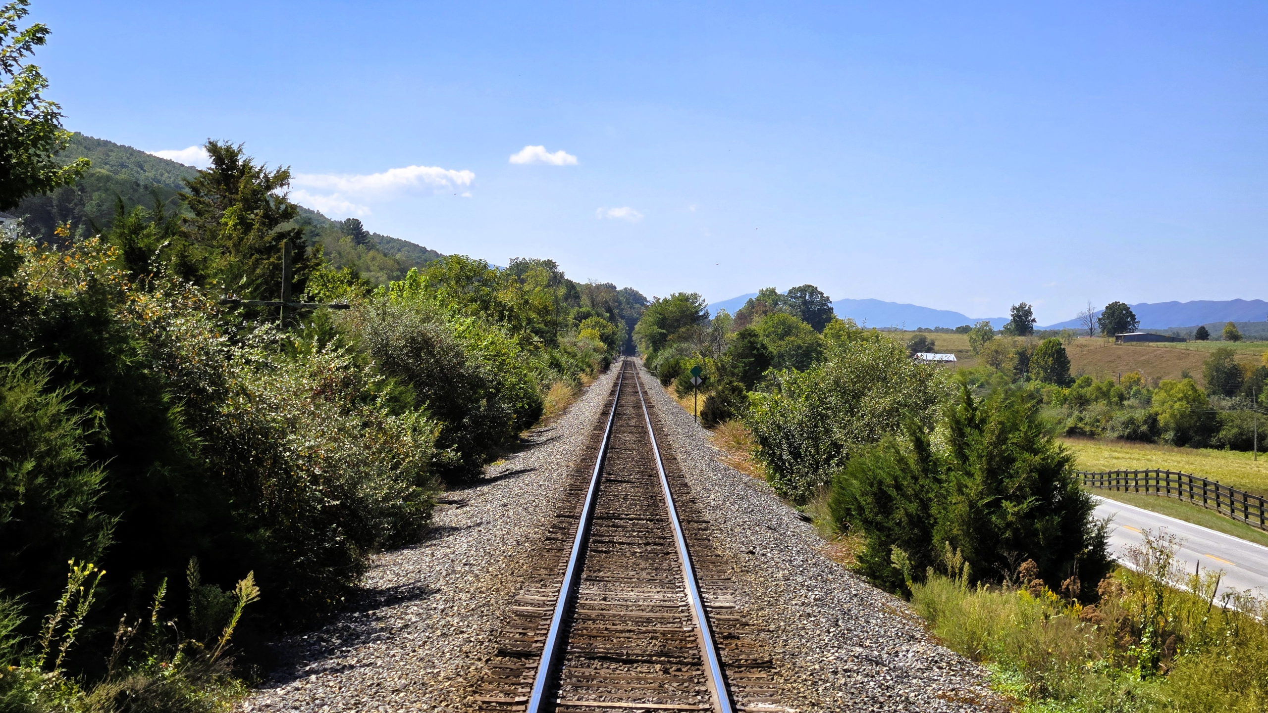 train tracks going off into the distance with mountains in the background on the Virginia Scenic Railway